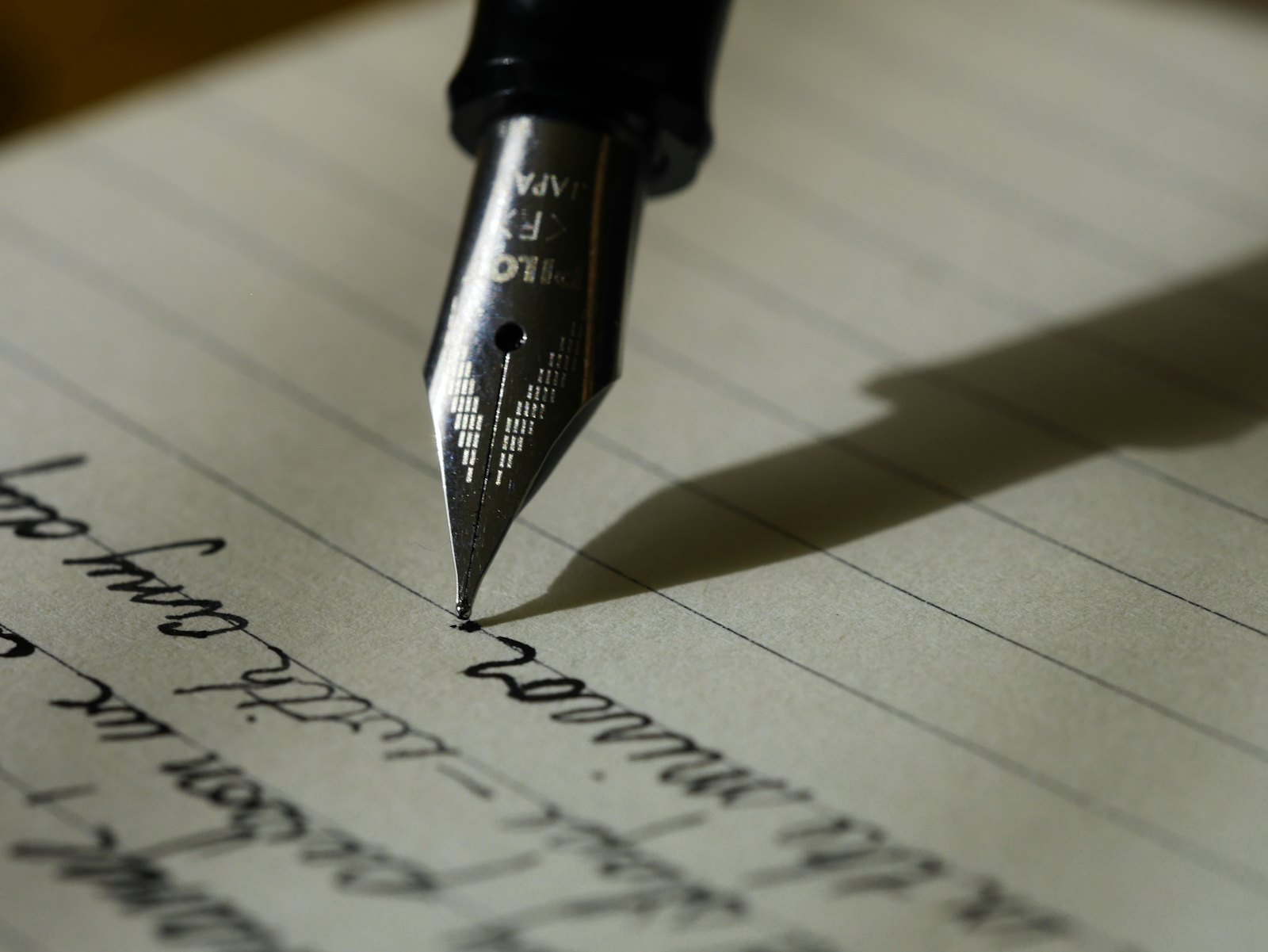 An open notebook and pen on a wooden table, waiting for the next page